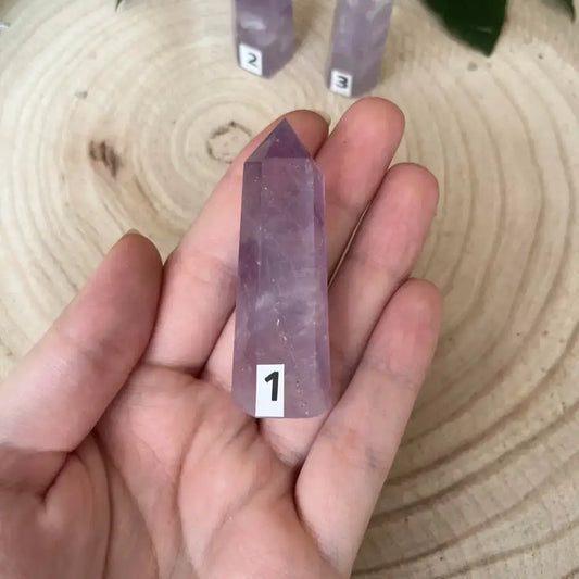 Améthyste en Pointe de la marque Aura de Roche, tenue dans une main, brillante et élégante