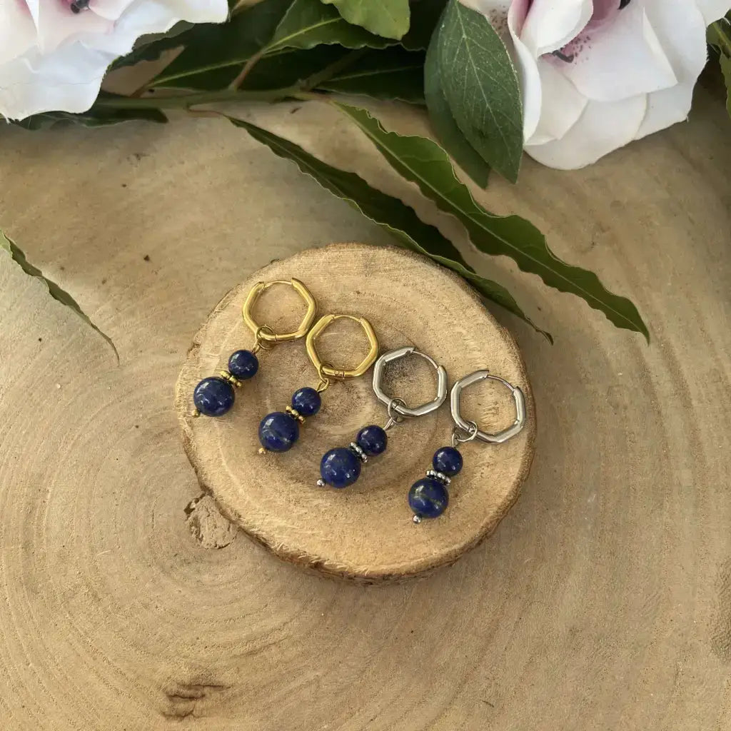 Boucles d'Oreilles Lapis Lazuli en argent et en or avec des perles brillantes sur un support en bois