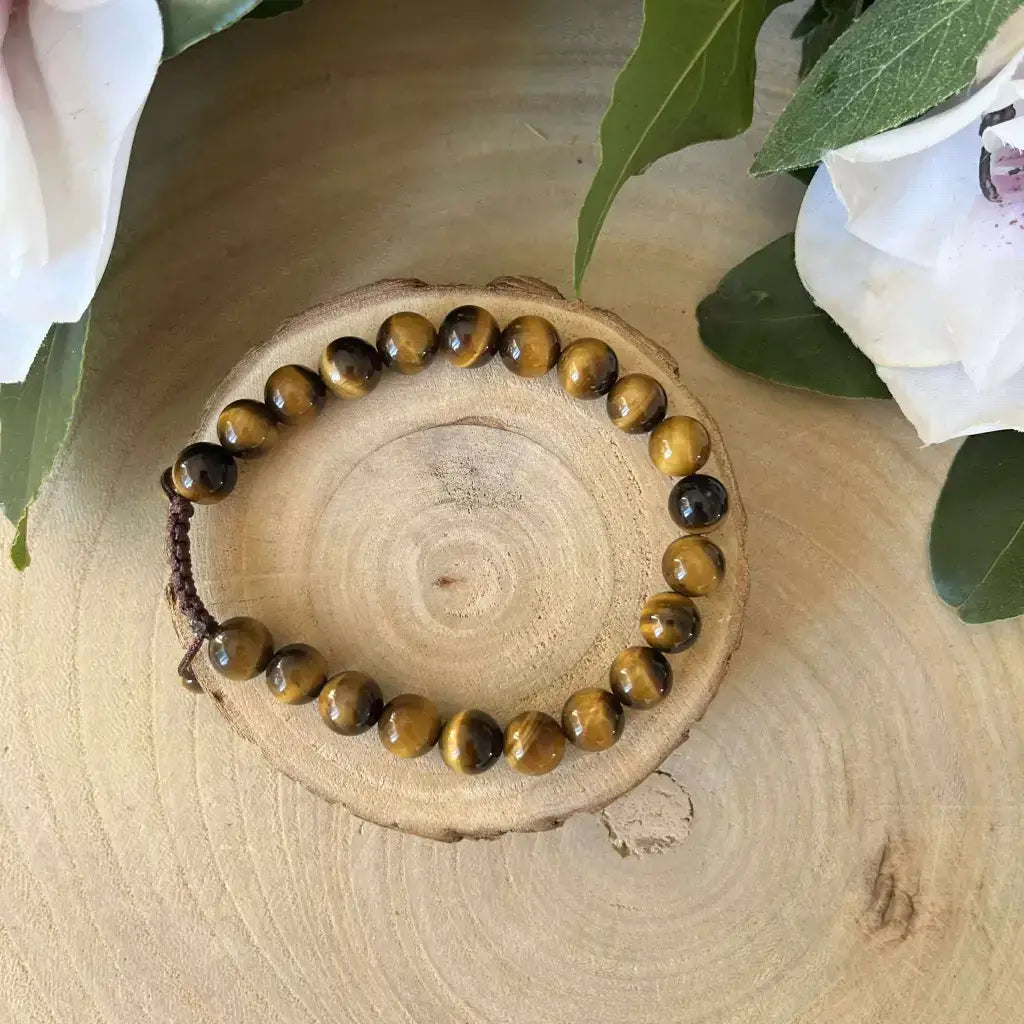 Bracelet Shambala Oeil de Tigre avec pierres naturelles sur un support en bois