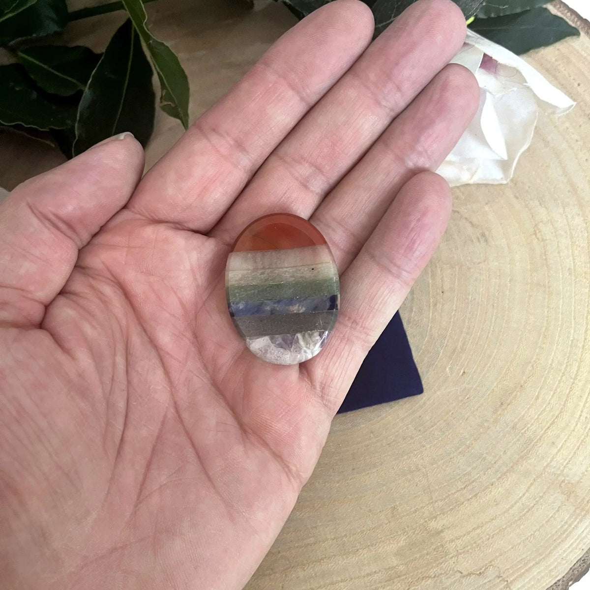 Galet anti-stress 7 chakras tenu dans la main
