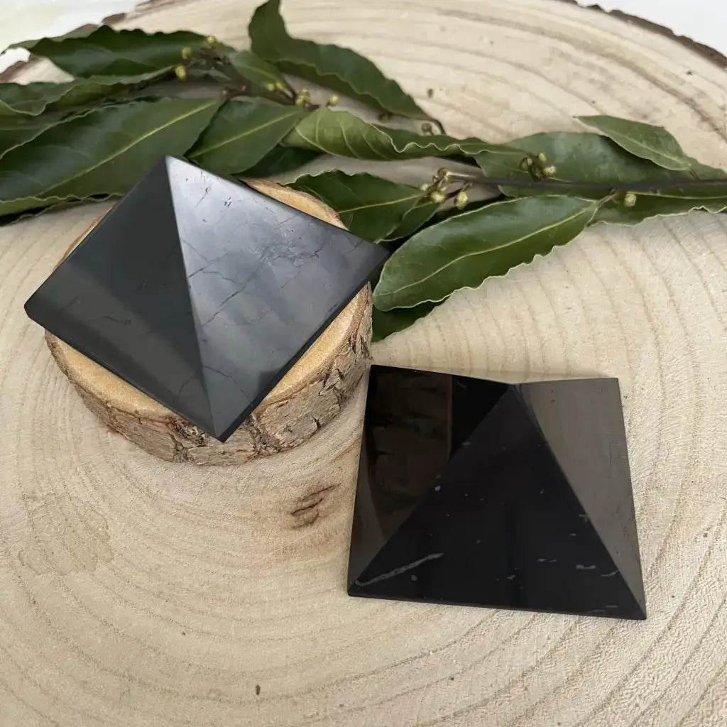 Pierre pyramide de shungite protection sur une coupelle en bois, parfaite pour l'harmonisation des énergies