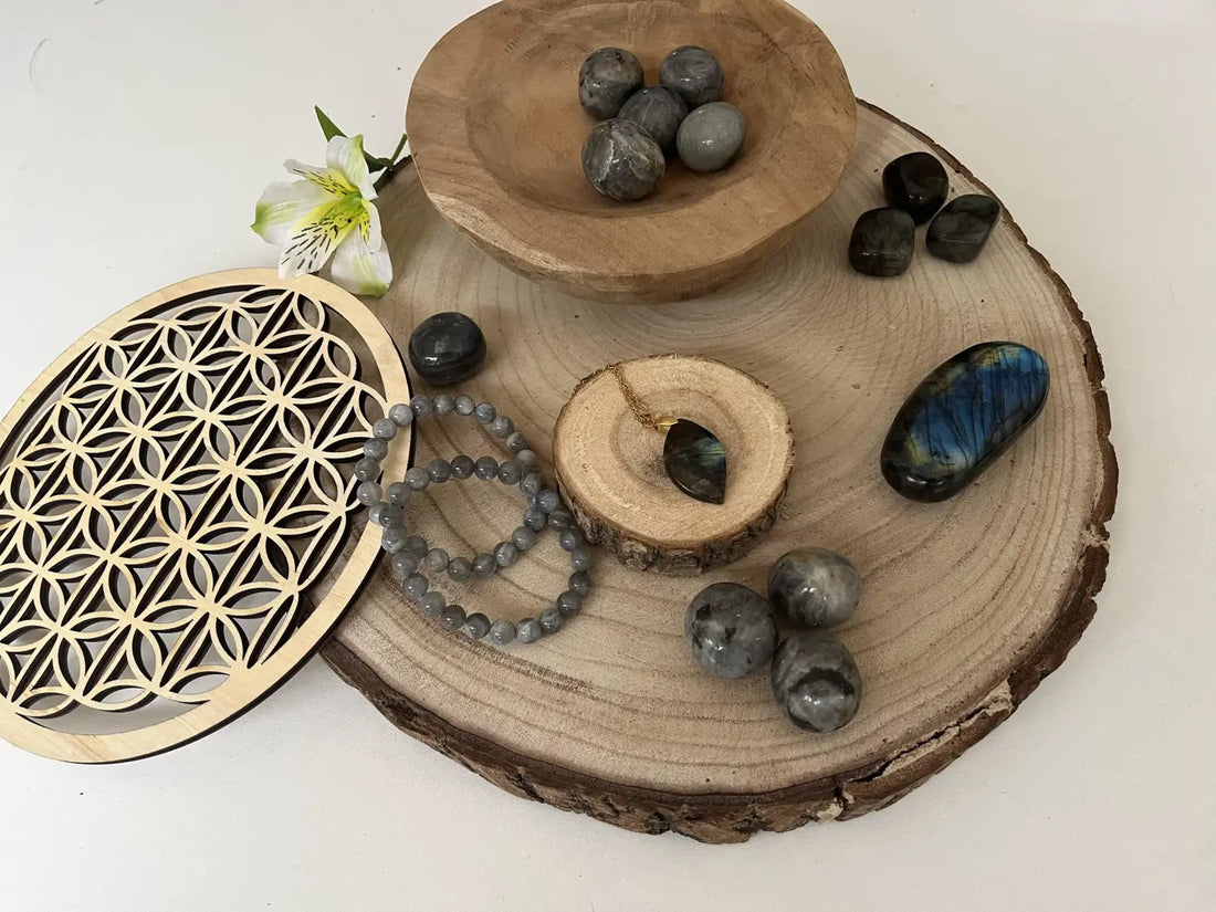 Découverte de la Labradorite avec plusieurs pierres, bracelets et un bol en bois sur une planche en bois naturel