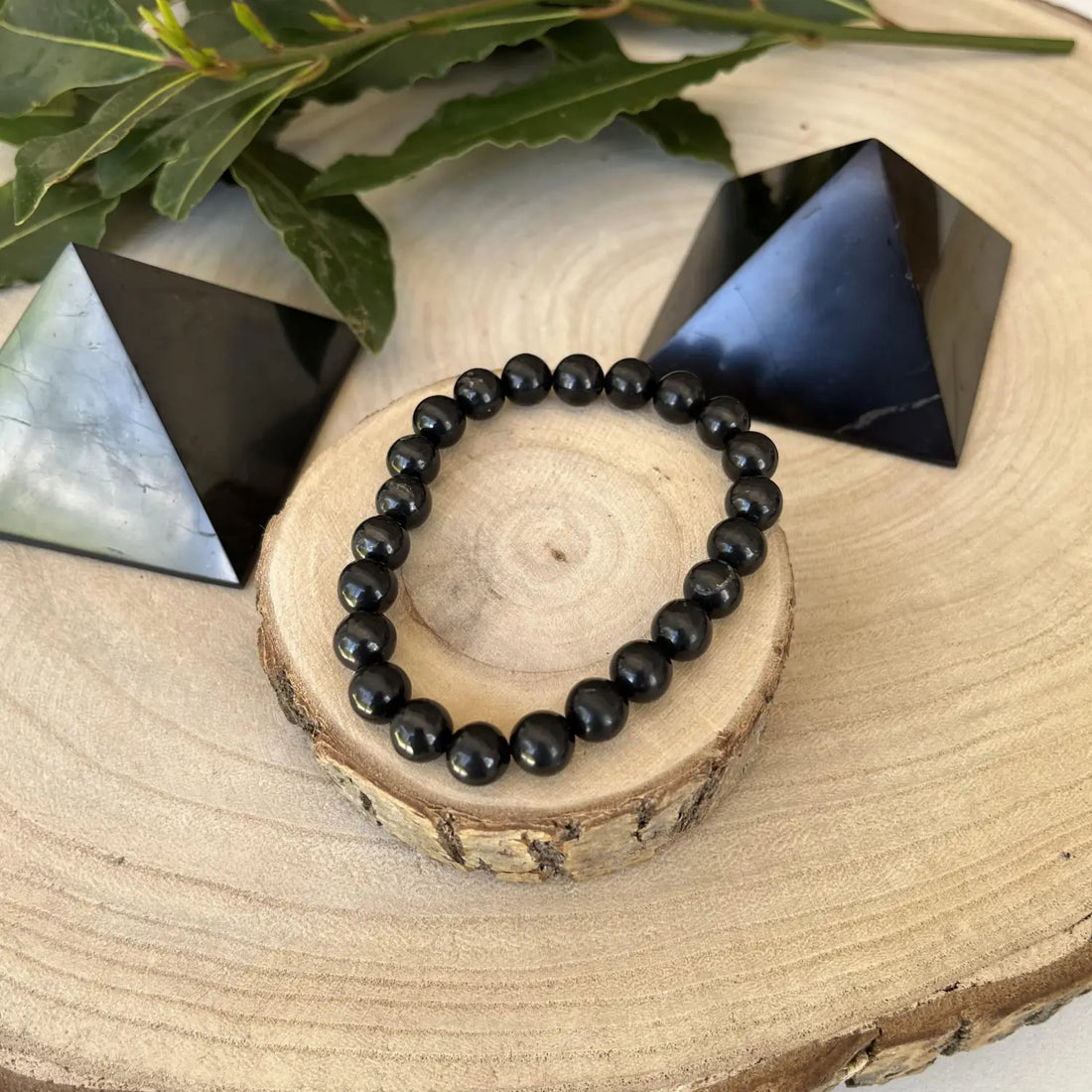 Bracelet en shungite entouré de pyramides en shungite pour découvrir les bienfaits de la Shungite