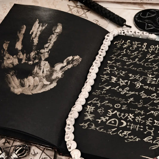 Symboles ésotériques et dessin de main sur un livre évoquant Le Mauvais Œil et la protection spirituelle