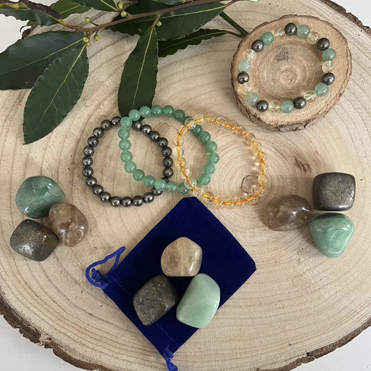 Collection de bijoux et pierres naturelles pour la réussite, incluant la pyrite et la citrine.