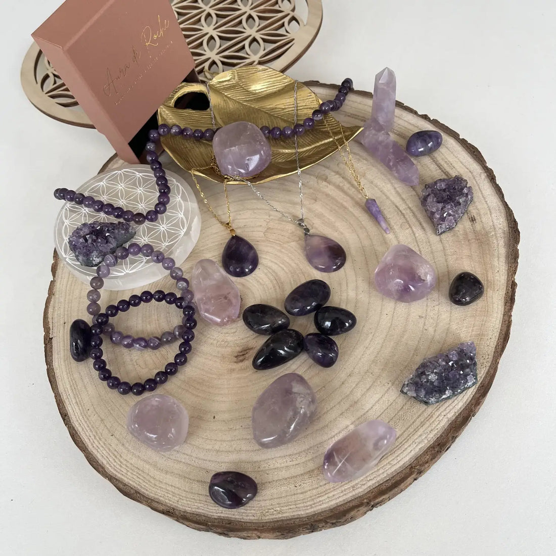 Collection de bijoux en pierre améthyste naturelle sur une écorce de bois avec divers cristaux violets