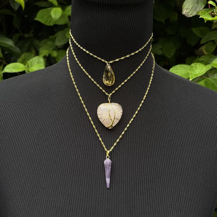 Trois colliers en pierre naturelle avec pendentifs en quartz rose, améthyste et citrine sur un mannequin