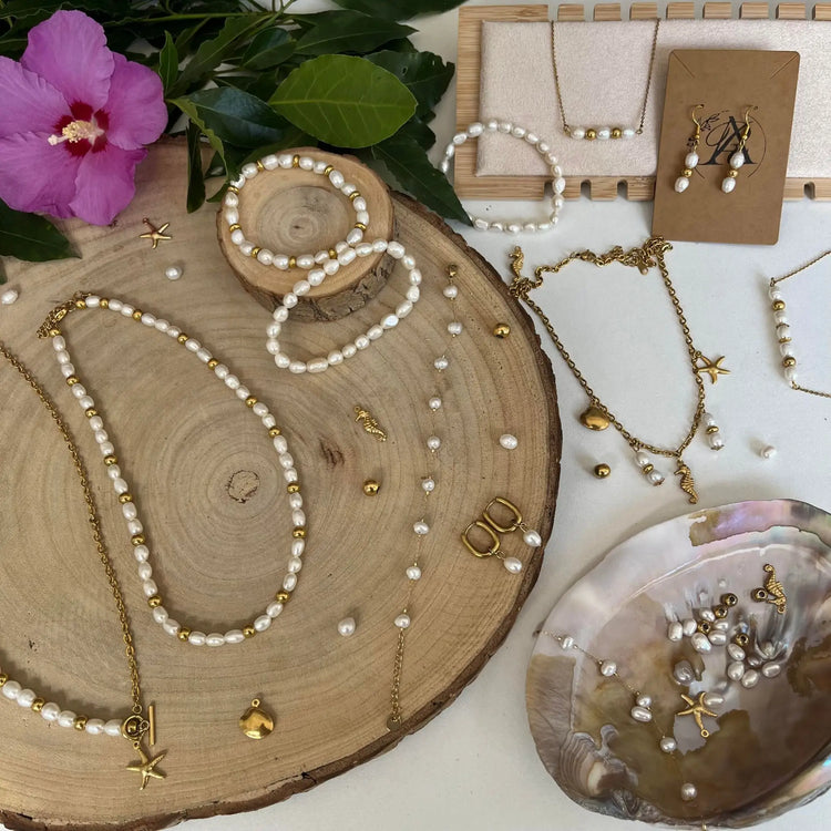 Collection Éclats d'Eau Douce avec bijoux en perles d'eau douce et acier inoxydable doré sur un plateau en bois