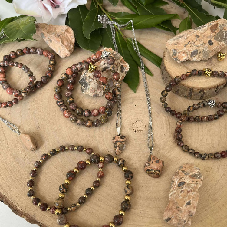 Collection de bijoux en Pierre Jaspe Léopard sur un plateau en bois, présentant des motifs uniques et élégance naturelle.