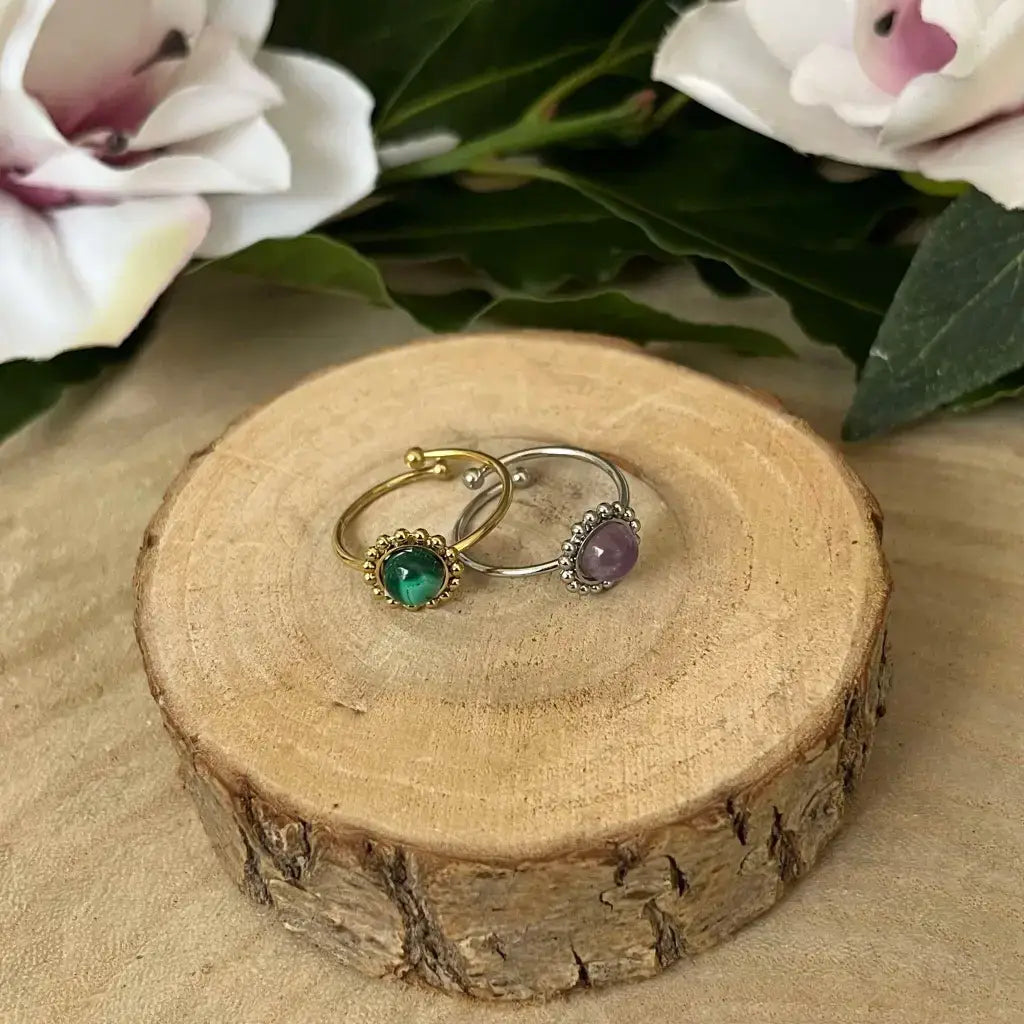 Bague ajustable Solara Aura de Roche en argent et or avec pierres vertes et violettes sur bois naturel