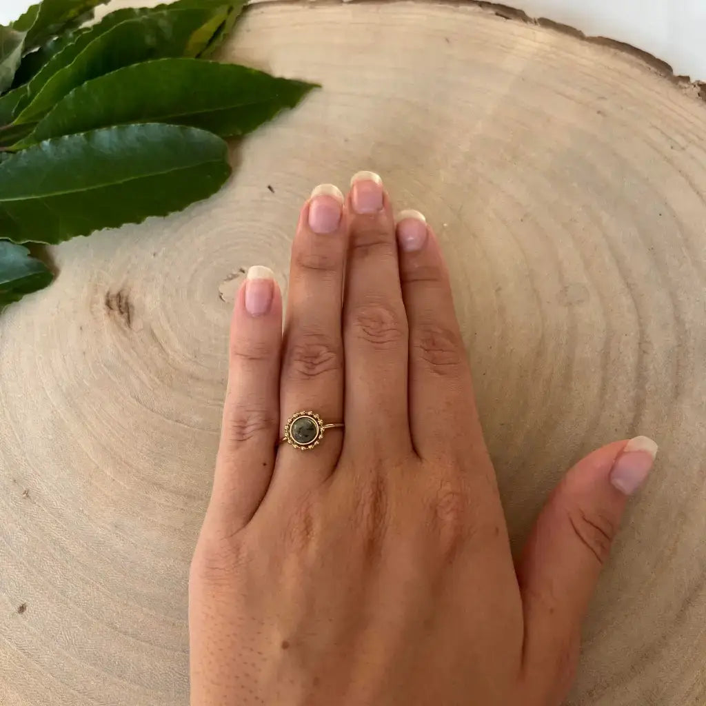 Bague ajustable Solara Aura de Roche portée sur la main avec pierre verte et finition dorée