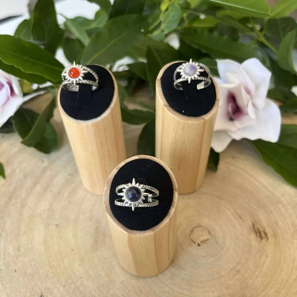 Bague ajustable Soleil de Aura de Roche en argent avec pierre colorée présentée sur support en bois