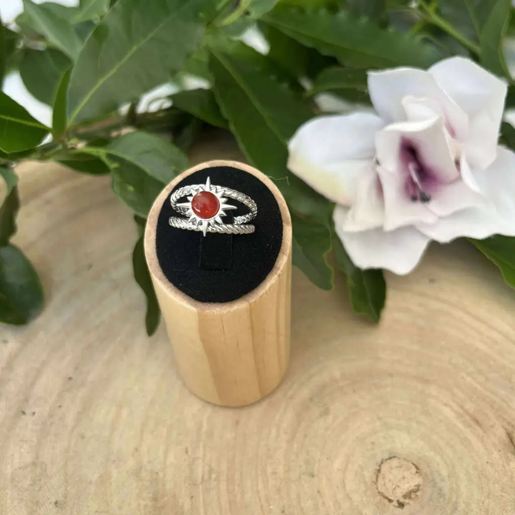 Bague ajustable Soleil signée Aura de Roche avec pierre rouge sur présentoir en bois
