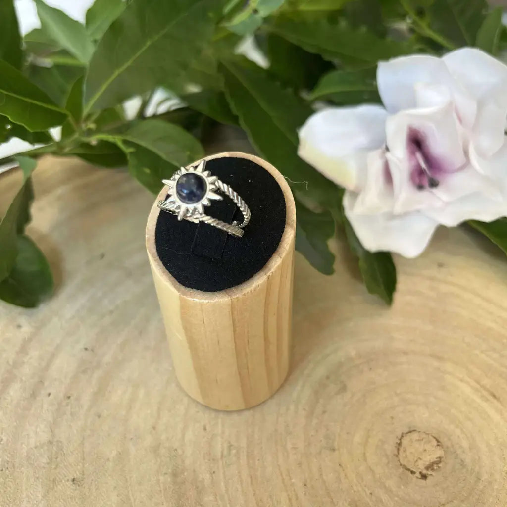 Bague ajustable Soleil en argent avec pierre noire sur présentoir en bois Aura de Roche