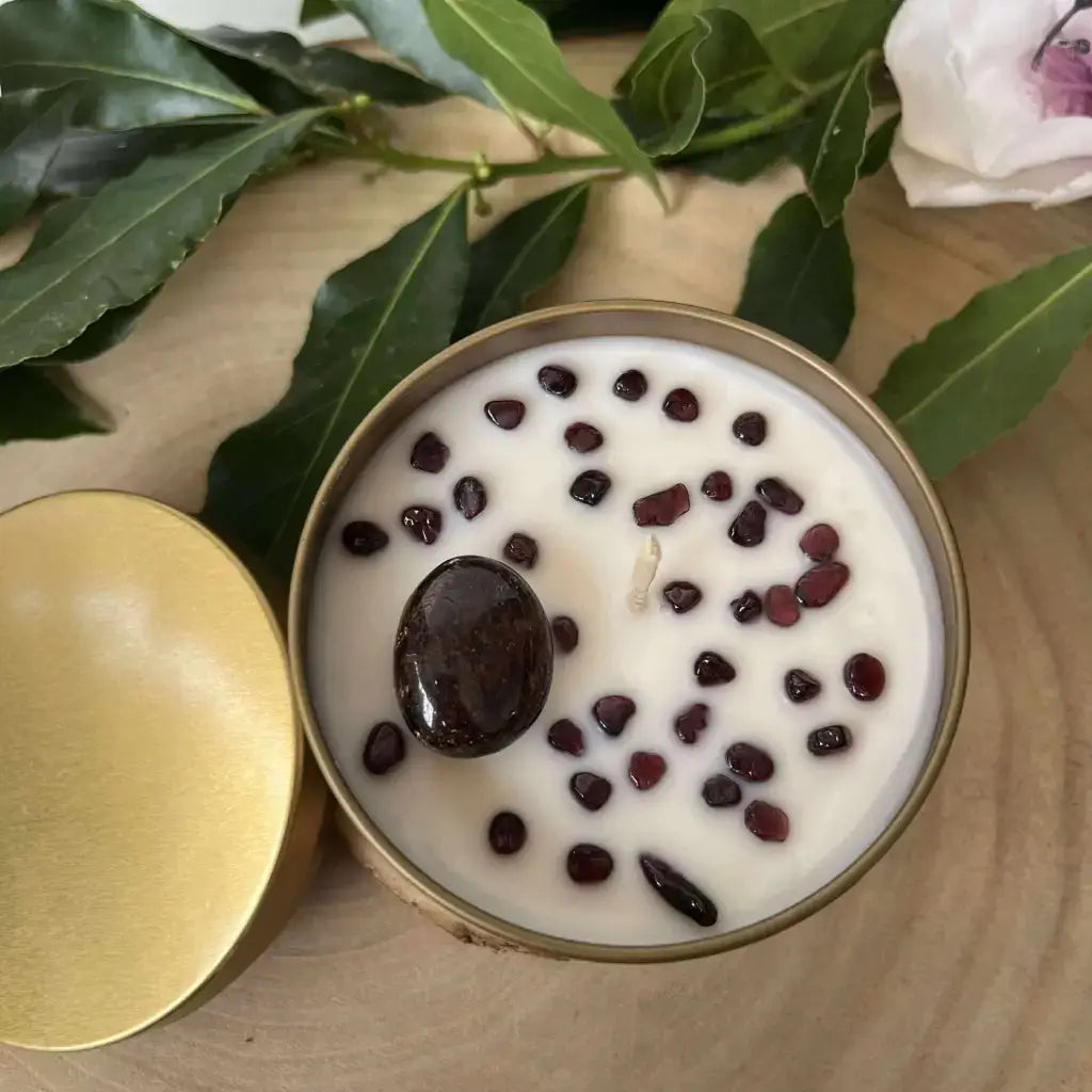 Bougie Aphrodisiaque en Grenat avec pierres naturelles et couvercle doré sur une surface en bois