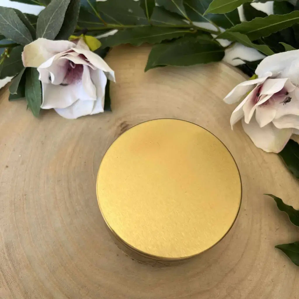 Bougie Protection en Œil de Tigre Aura de Roche dans boîte ronde dorée sur tranche de bois avec fleurs