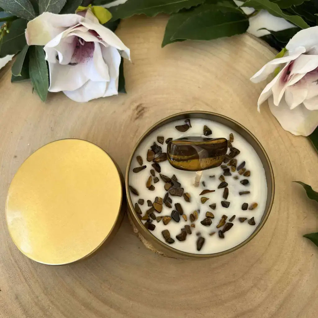 Bougie Protection en Œil de Tigre en boîte dorée, cire blanche avec pierre centrale et éclats sur fond bois