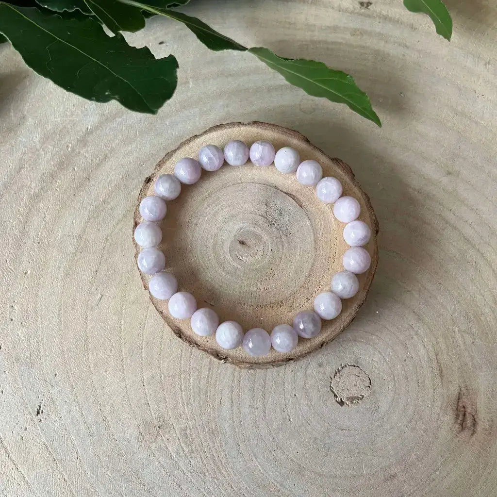 Bracelet en Kunzite rond sur un plateau en bois, idéal pour un look élégant et naturel
