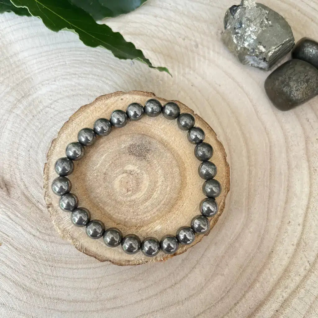 Bracelet en pyrite naturelle avec perles brillantes sur un support en bois