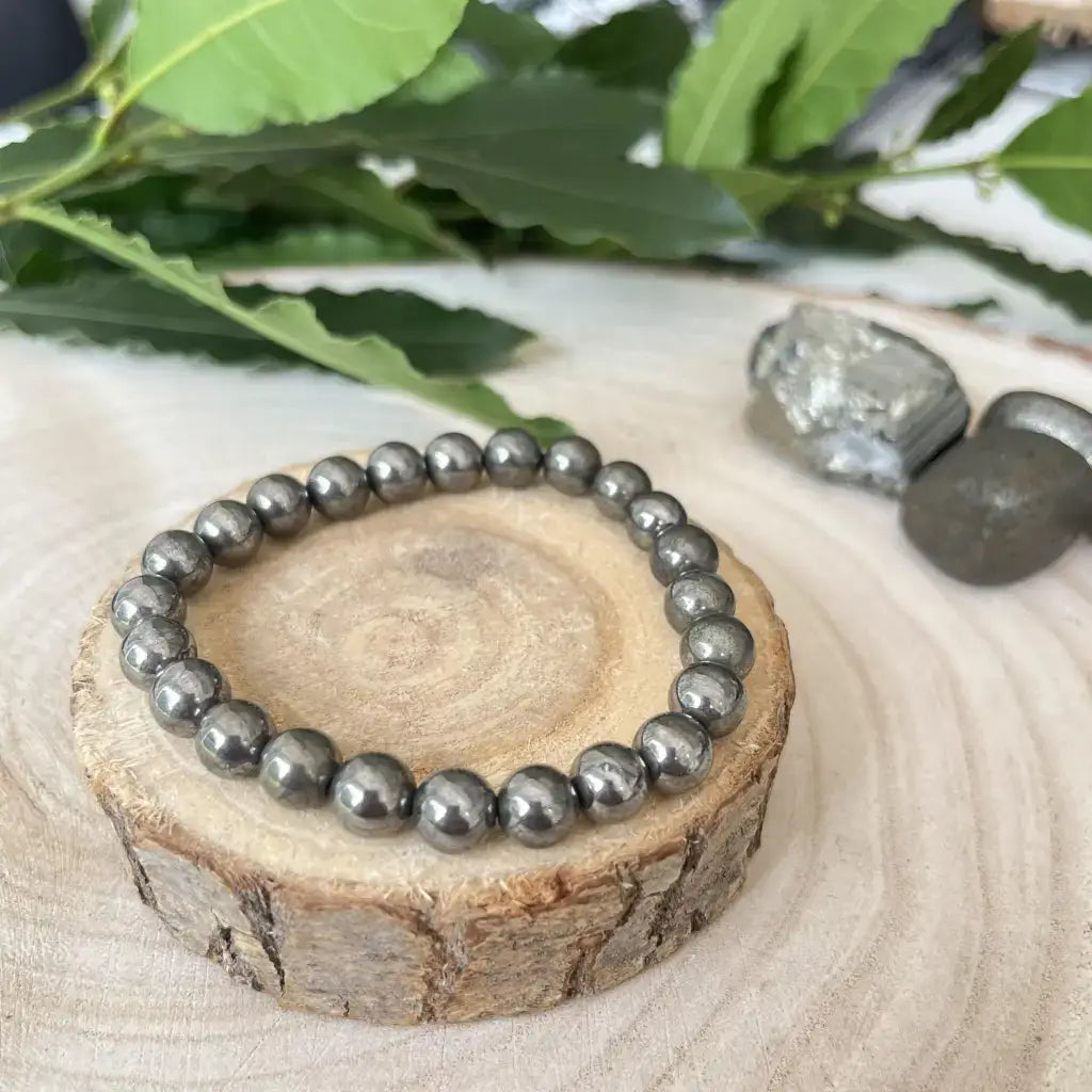 Bracelet en pyrite naturelle avec perles brillantes sur un support en bois naturel