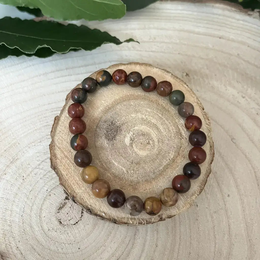 Bracelet Jaspe Picasso en perles multicolores sur un support en bois naturel