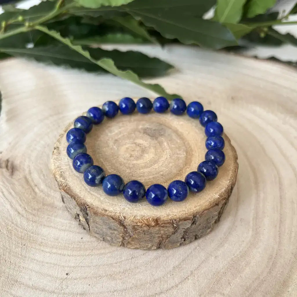Bracelet Lapis Lazuli en perles brillantes sur socle en bois naturel