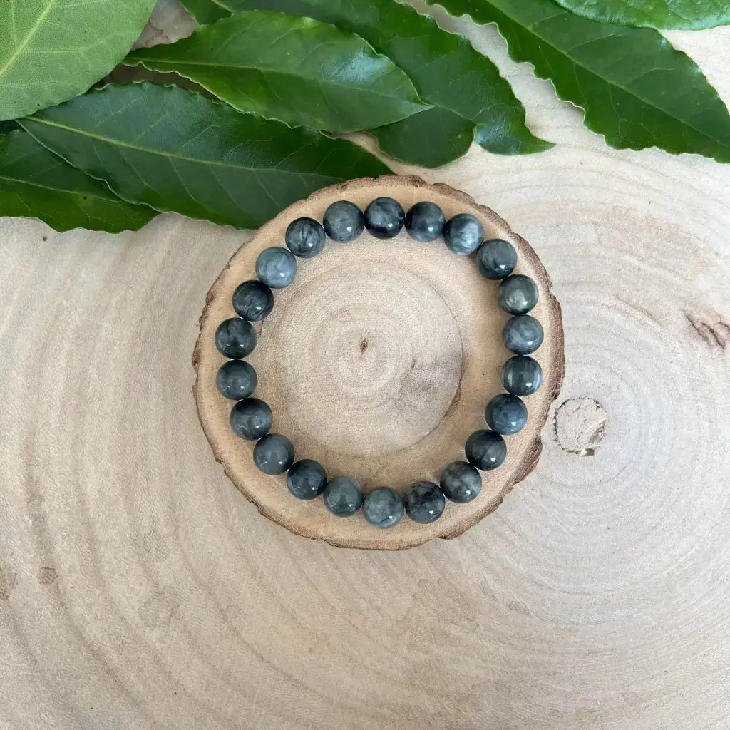 Bracelet Oeil de Chat en pierres naturelles grises sur un support en bois décoratif
