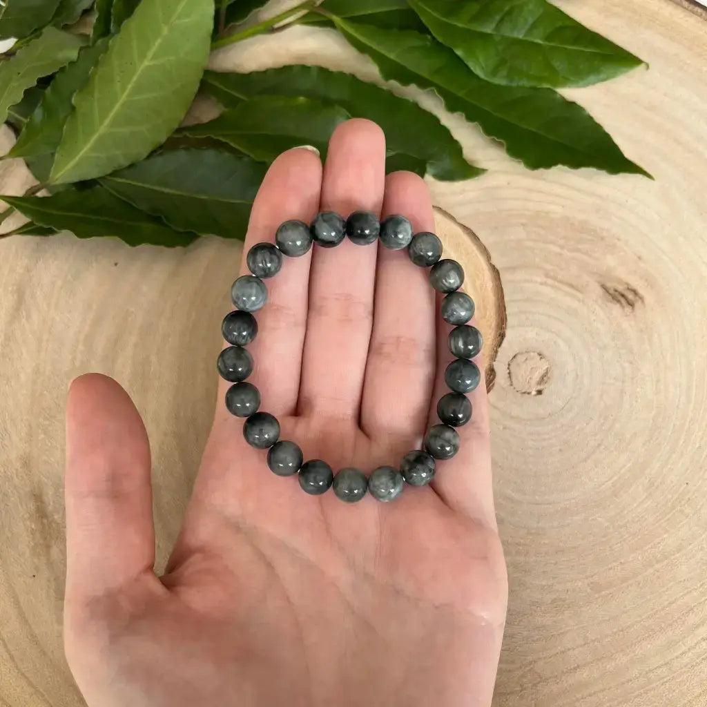 Bracelet Oeil de Chat en perles grises sur une main, parfait pour un style élégant et naturel