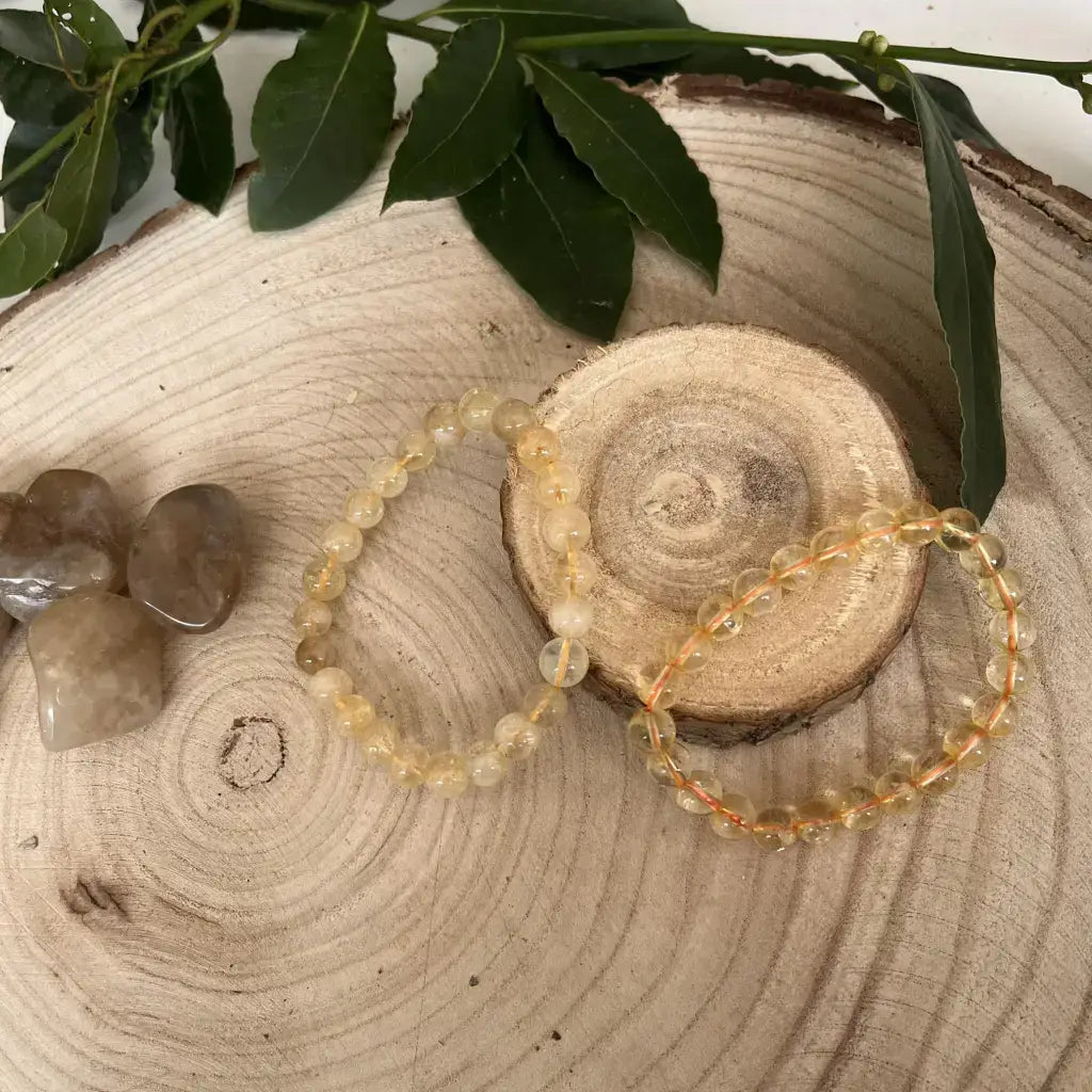 Bracelet Perle Citrine en pierres naturelles sur une tranche de bois avec d'autres pierres