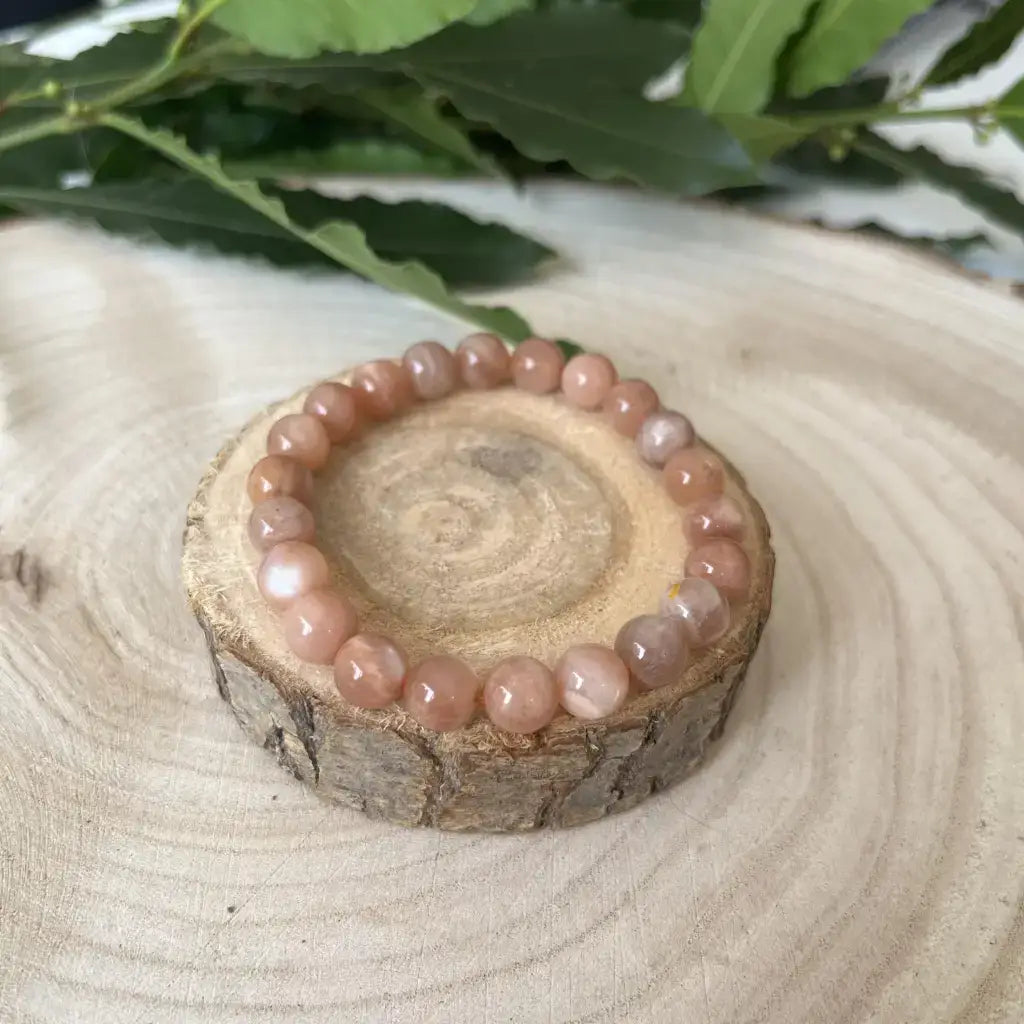 Bracelet Pierre de Soleil en perles douces sur un support en bois naturel