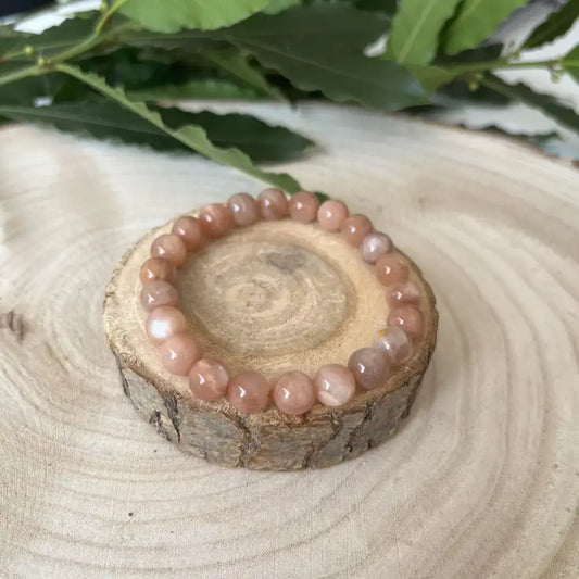 Bracelet Pierre de Soleil en perles douces sur un support en bois naturel