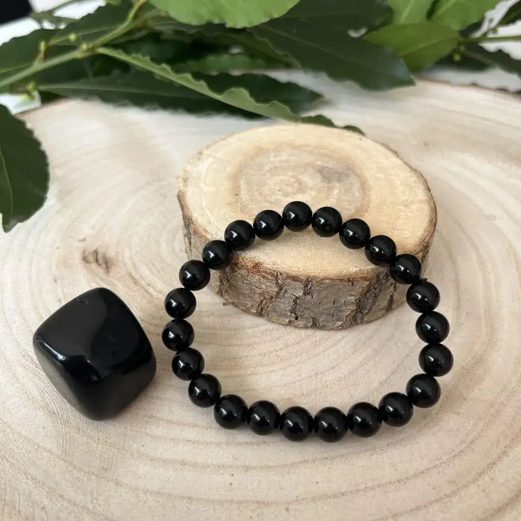 Bracelet & Pierre Obsidienne en perles brillantes sur un support en bois