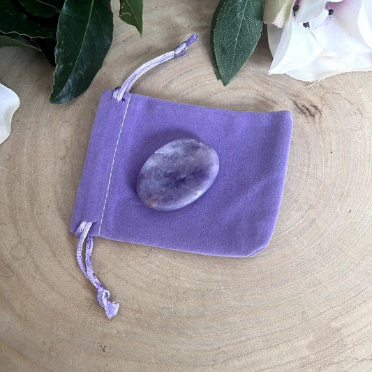 Galet anti-stress en améthyste posé sur son pochon violet