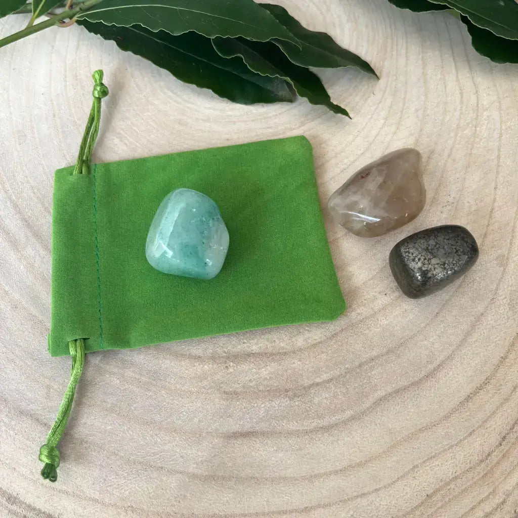Kit de Réussite avec Pierres Naturelles comprenant trois pierres dans un sac vert en suédine