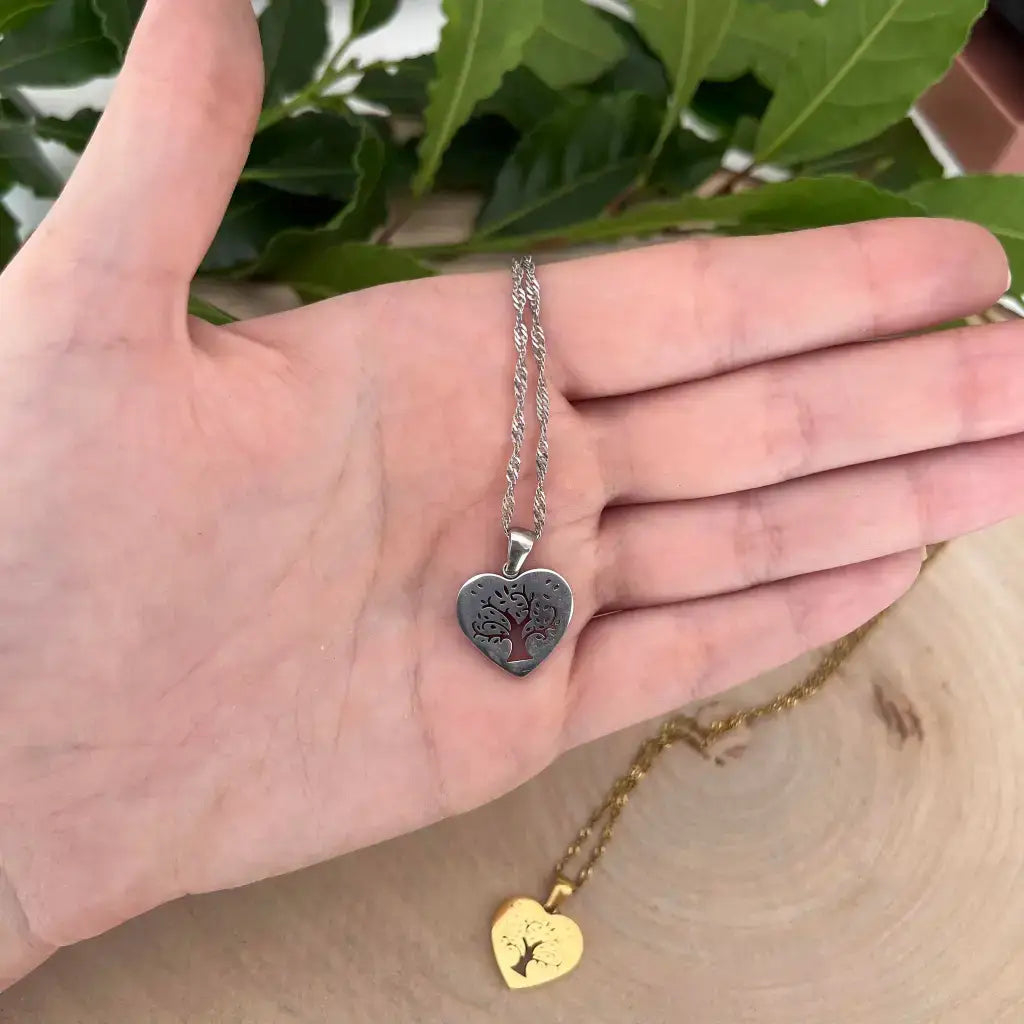 Collier Pendentif Cœur avec Arbre de Vie en acier posé sur une main chaîne et pendentif doré en arrière