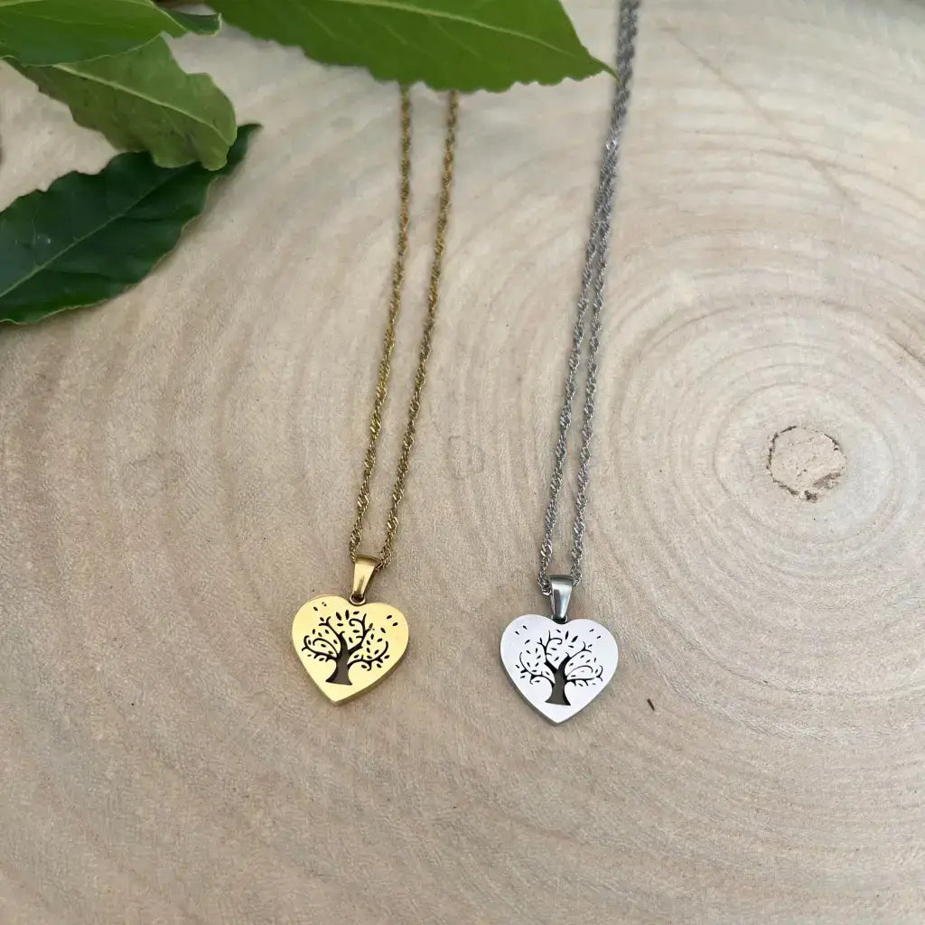 Pendentif Cœur avec Arbre de Vie Aura de Roche deux colliers cœur doré et argenté posés sur bois