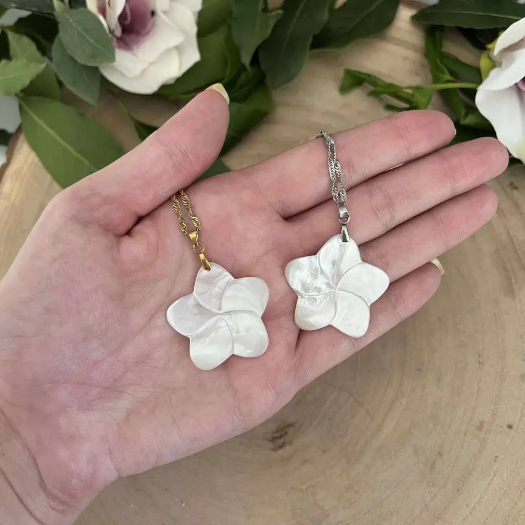 Pendentif Fleur en Nacre Aura de Roche avec chaîne dorée et chaîne argentée porté sur une main