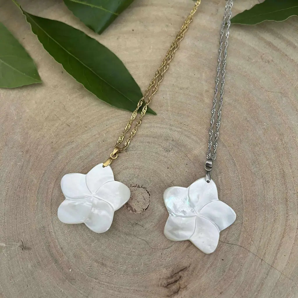 Pendentif Fleur en Nacre Aura de Roche avec chaîne dorée et argentée sur fond bois naturel