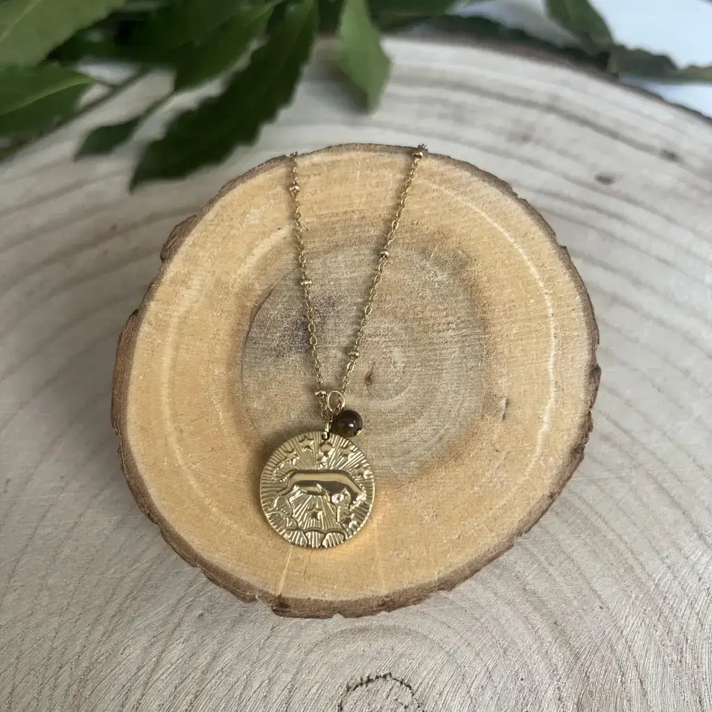 Pendentif Taureau avec Pierre de Pouvoir en or avec un design gravé sur un support en bois