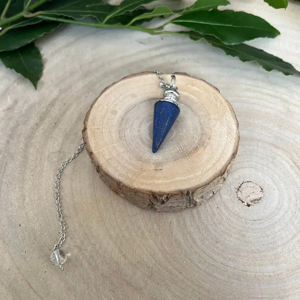 Pendule en Lapis Lazuli avec chaîne en argent sur un support en bois naturel