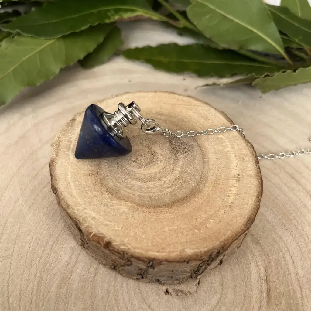 Pendule en Lapis Lazuli en forme de cône avec chaîne en métal sur un support en bois