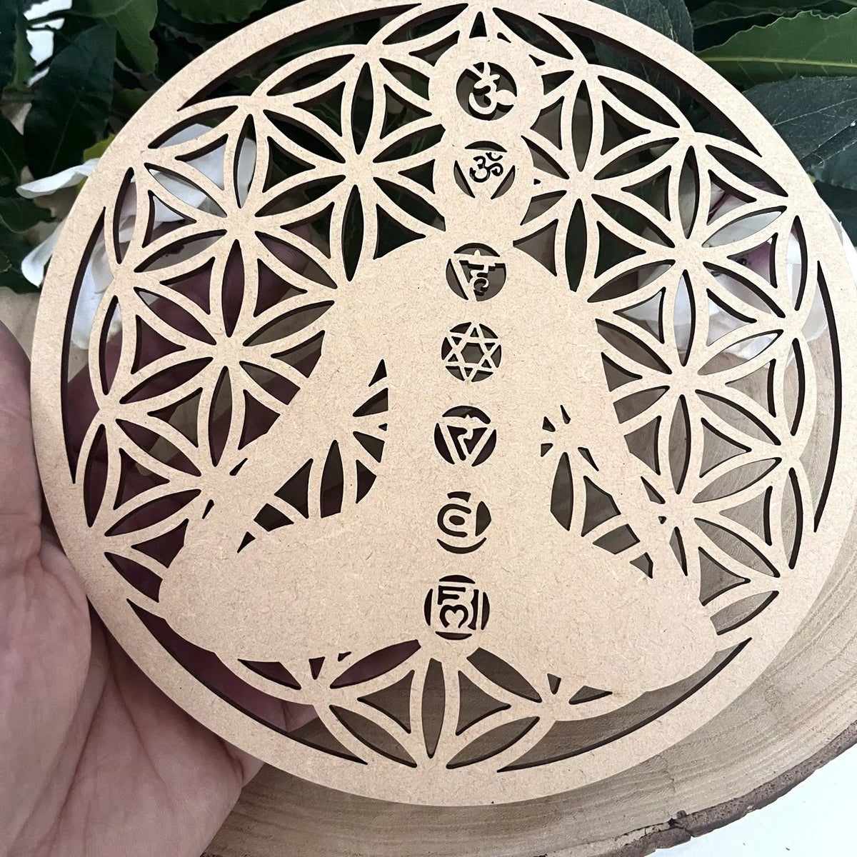 Plaque fleur de vie 7 chakras en bois tenue dans la main
