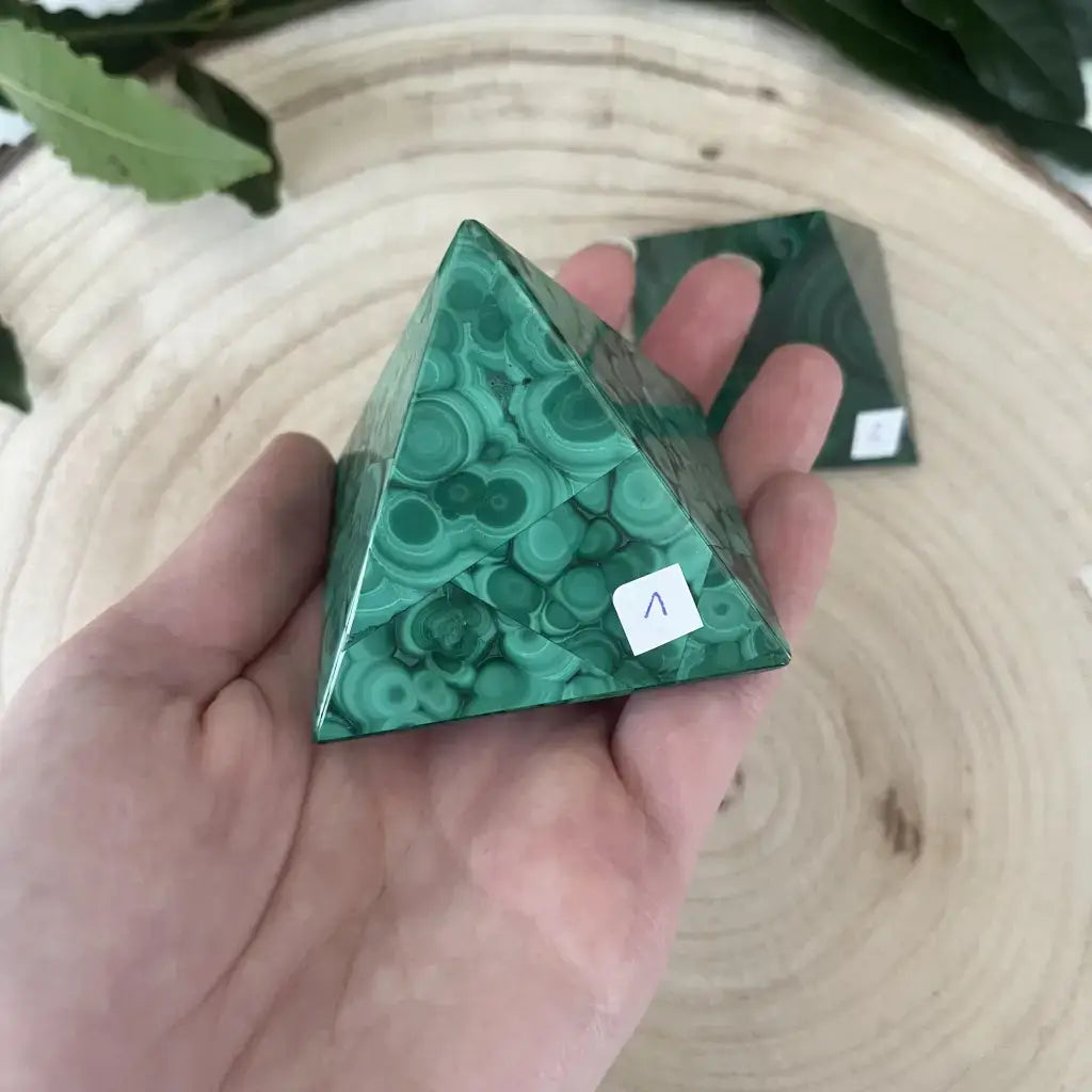 Pyramide de Malachite décorative en main, montrant ses magnifiques motifs verts et son éclat pour la décoration intérieure