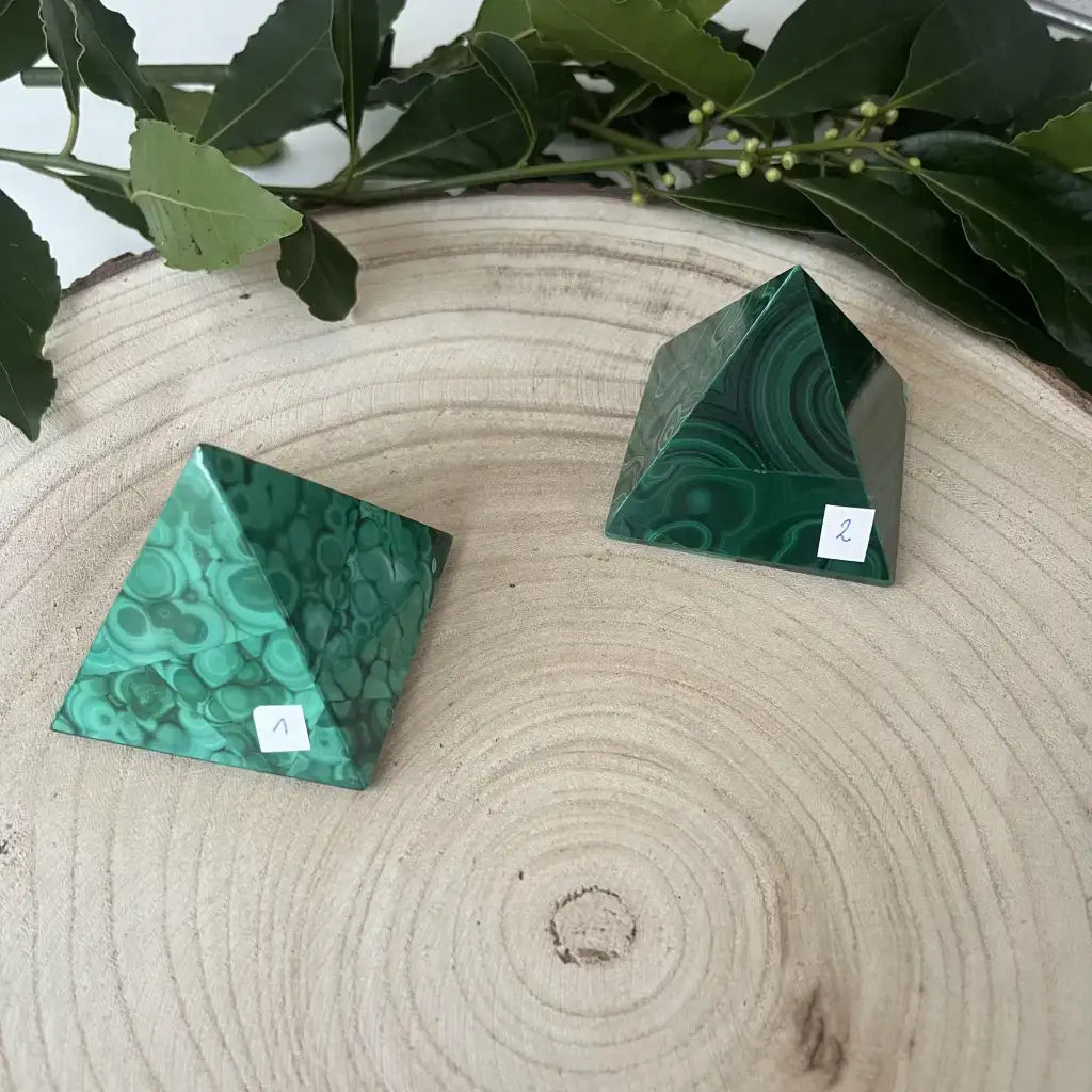 Deux pyramides de malachite sur une planche en bois, idéales pour la décoration et la méditation