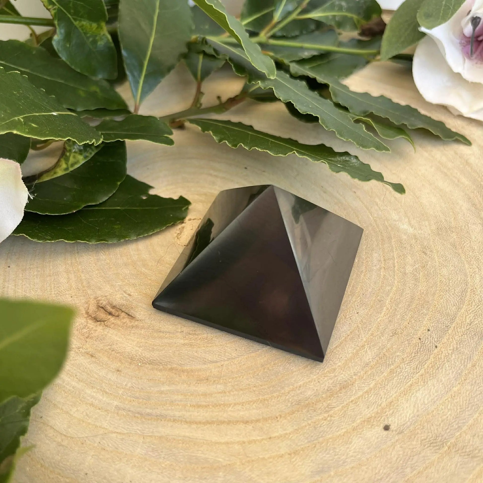 Une pyramide en shungite noire polie avec des facettes lisses pour la protection contre les ondes nocives